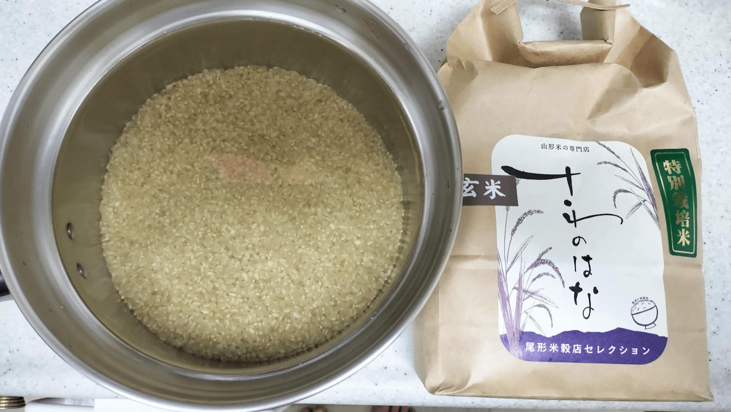 Brown rice variety "Sawanohana" soaked in plenty of water in a pot.